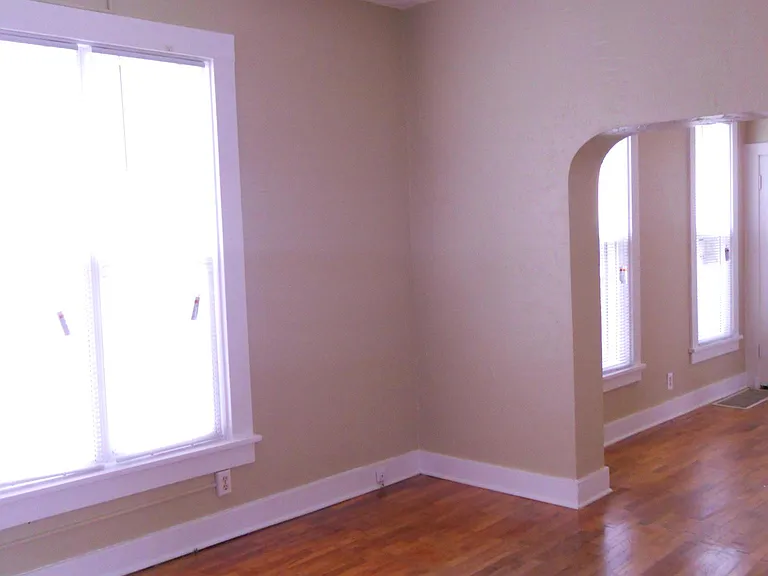 Living room into the dining room. Note the arched walk through and the ceiling fan