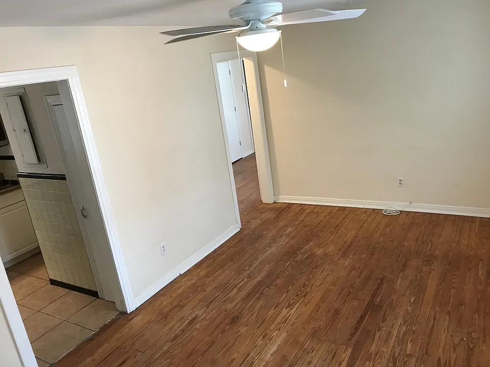 Living room features hardwood floors and new ceiling fan.