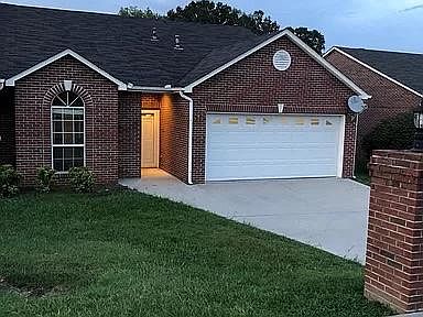 Front of property with full yard and two car garage