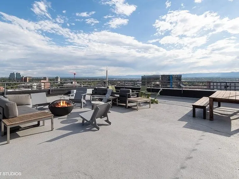 Rooftop patio with a fire pit and seating area at Archer Tower in Denver, CO