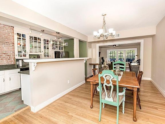 Open kitchen and dining with farmhouse style kitchen cabinets. There is plenty of cabinet storage! Please note that the unit has been painted a neutral grey. These photos were taken previously to interior paint. Condo is currently not furnished.