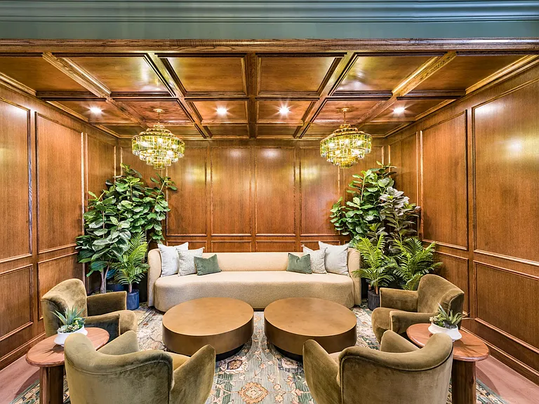Parlor lounge with rich wood paneling, layered seating, and statement lighting creating a warm setting for conversation and quiet moments.