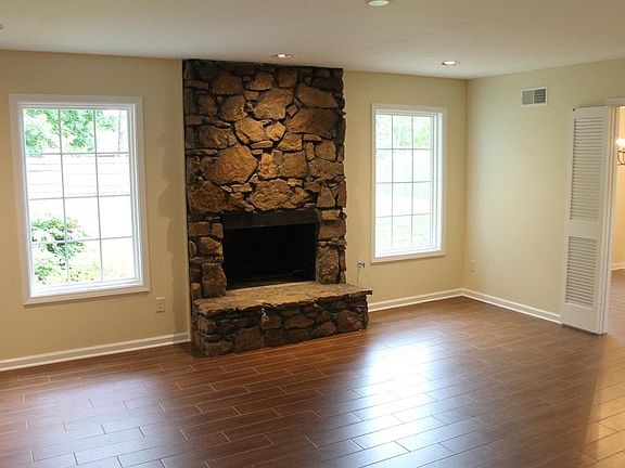 Den w/ fireplace and back yard views.
