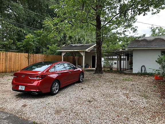 gravel parking and covered carport with storage room