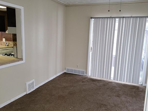 Formal dinning room with pass-thru window to kitchen, and sliding door leading to 3-season room.