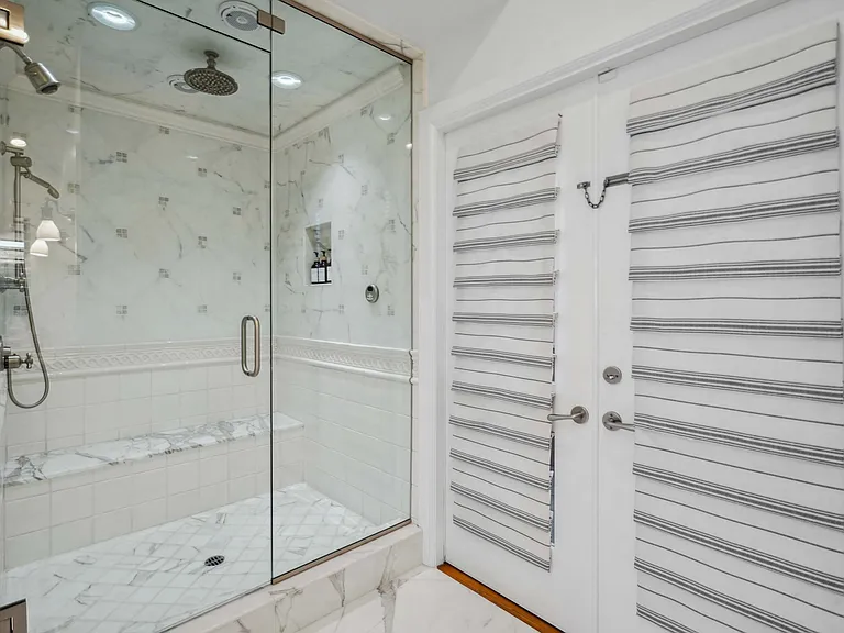 Chrome rain showerhead and fixtures offer a spa-like experience.