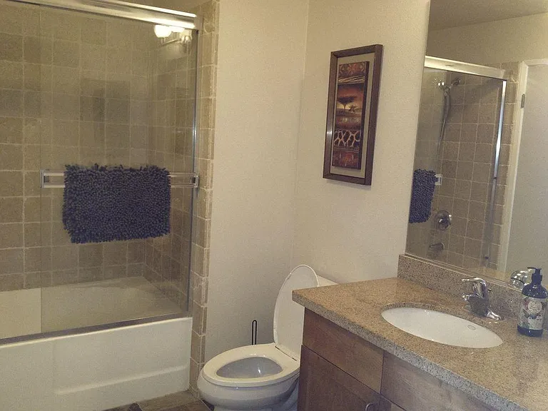 Large Bathroom w/ Tile Floors and Two Doors.