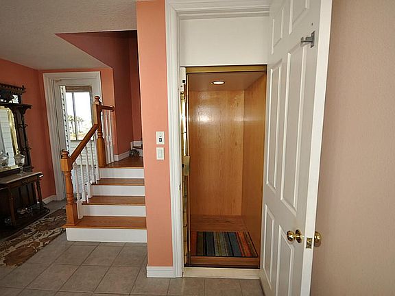 Entrance off front porch with stairs to top floor and an elevator that goes to all 3 levels.