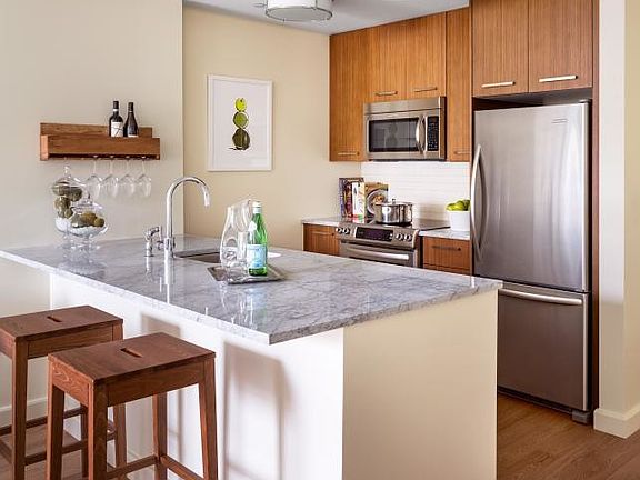 Walnut cabinetry, Italian marble countertops, and stainless steel appliances are just a few of the m