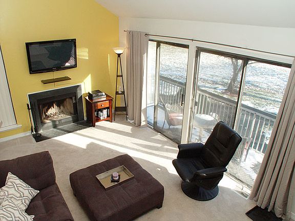 Living room with wood burning fireplace flooded with natural sunlight