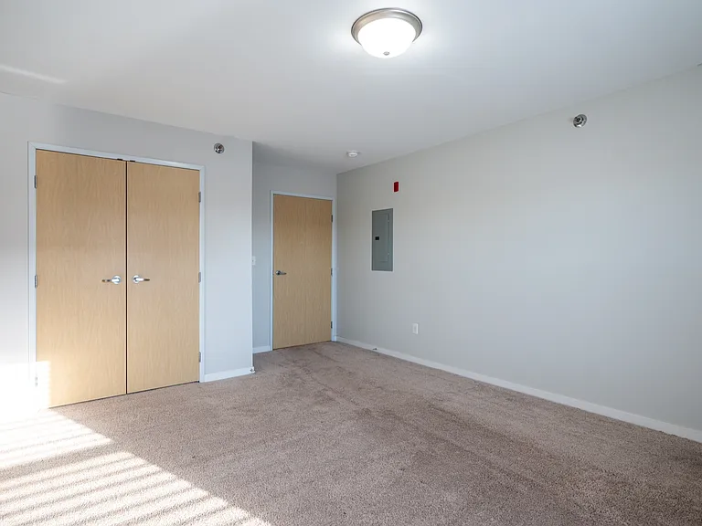 Bright and spacious room with plush carpet, ample closet space, and neutral walls for a serene atmosphere. Bright and spacious room with plush carpet, ample closet space, and neutral walls for a serene atmosphere.