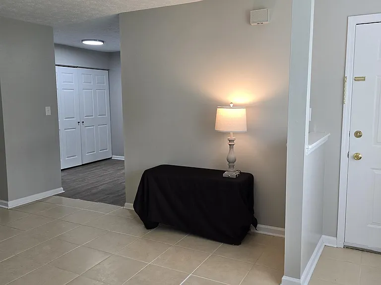 View from front corner of living room of adjacent dining area with laundry/storage closet. Kitchen and side entrance is around the corner.