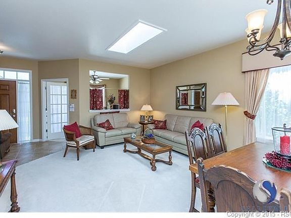 Another view of entry, office, living and dining rooms with rubbed bronze chandelier and skylight.