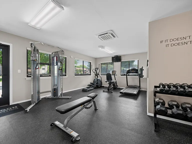 24-hour fitness center at cardio machines and weights at Woodland Villa Apartments in Westland, MI.