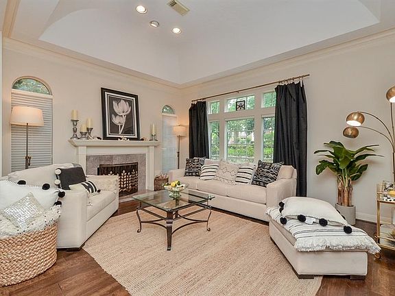 Beautiful wood flooring throughout living space. Formal living room with arched ceiling, crown molding, wall of windows and cozy fire place.