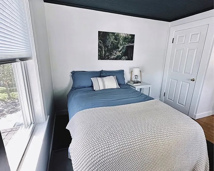 This is a double size bed. There is a small closet. There are two windows.