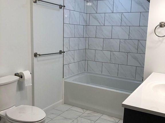 Large full bath has brand new fixtures, porcelain tile, and plenty of storage space.