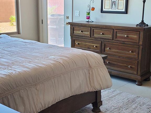 Master bedroom with king size bed showing entrance to the back patio.