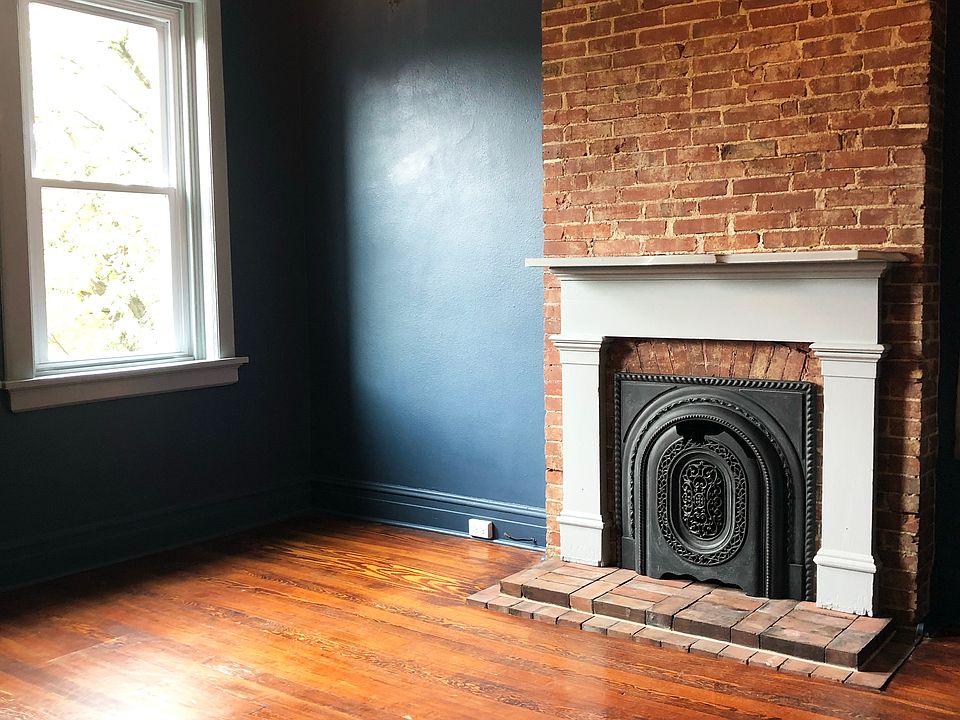 living room with exposed brick and a non-functional fireplace