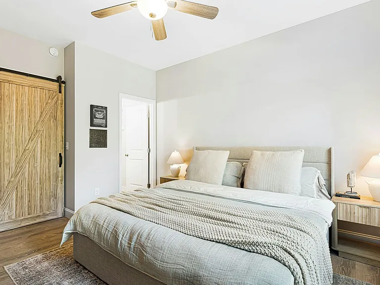 Primary bedroom suite, barn door to walk-in closet, then primary bath