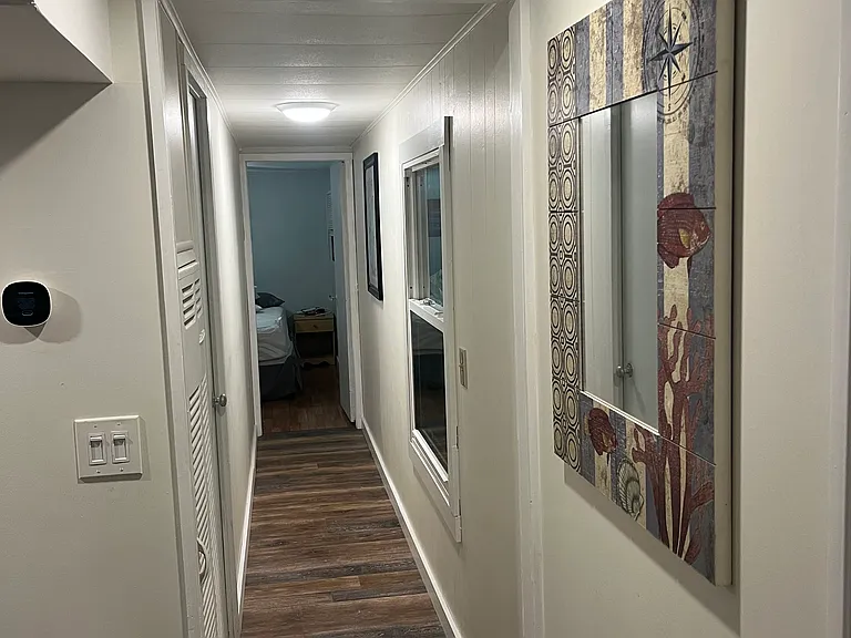 The main hallway. This leads to the primary bedroom with ensuite bath. Also off this hallway is a newly remodelled 1/2 bath with compact washer and dryer.