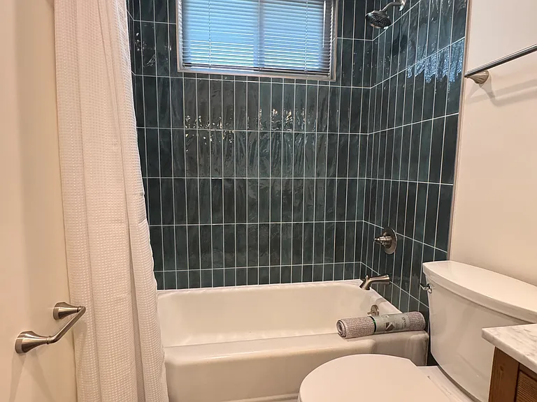 Updated bathroom with custom tiled shower, surround and floor