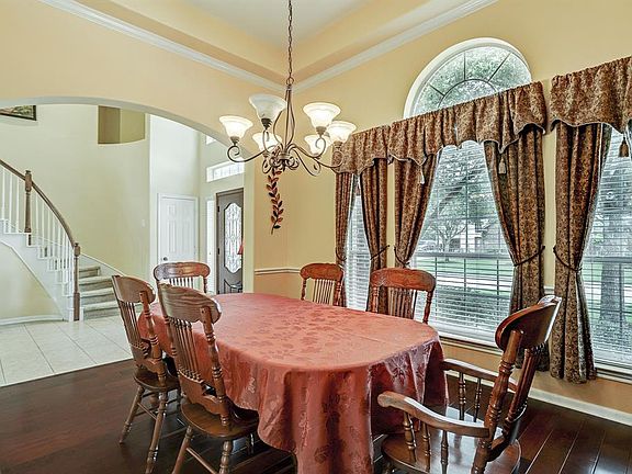 There is a formal dining room with extensive crown molding, hard wood floors, triple window with decorative window that overlooks the beautiful front yard.