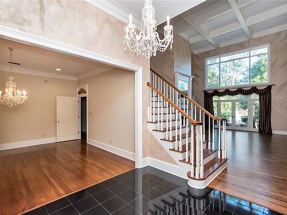 This expansive Great Room features a magnificent, 2-story, coiffured ceiling. Open the glass doors to step outside to the meticulously landscaped grounds.