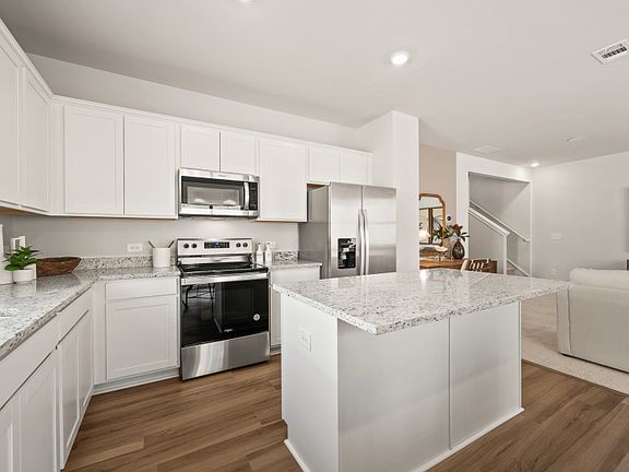 A spacious island with space to provide seating serves as a focal point for both meal preparation an