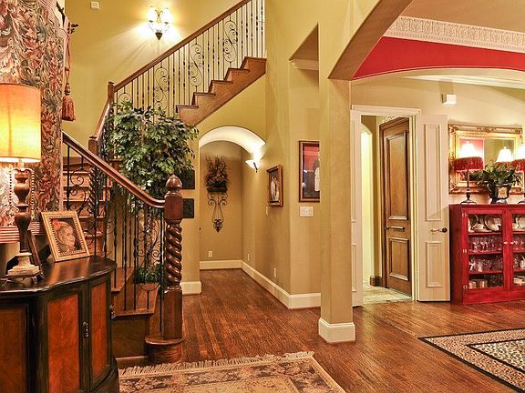 Oversized entry with iron rod stairway to upstairs