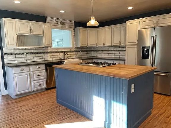 Kitchen with island and upgraded Kitchen Aid fridge.