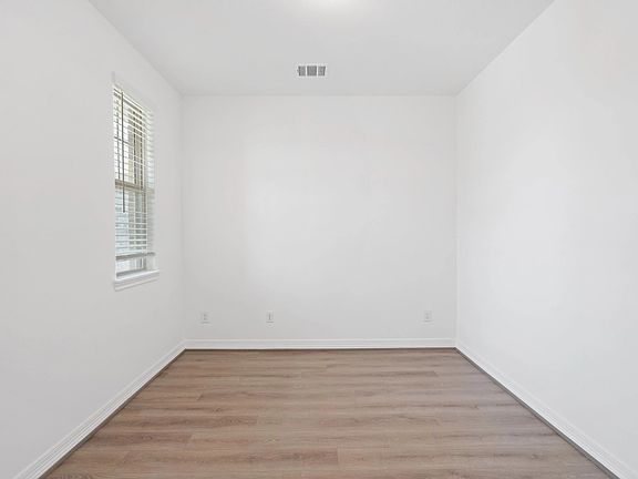 The home office features French doors, beautiful floors, large windows that give a fresh feel, this