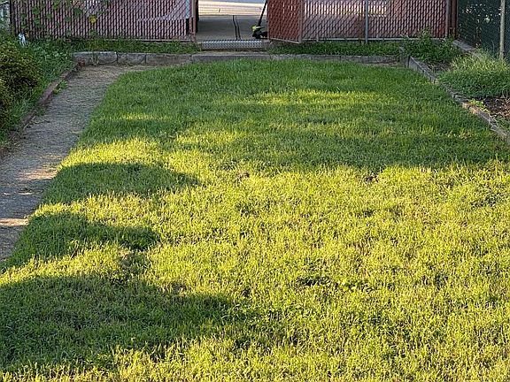 Fenced backyard with covered parking pad