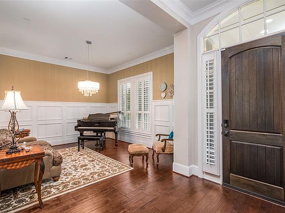 Gleaming hardwoods and high ceilings welcome you as you enter! This spacious room (18'x14')with stylish chandelier & wainscoting can function as a for