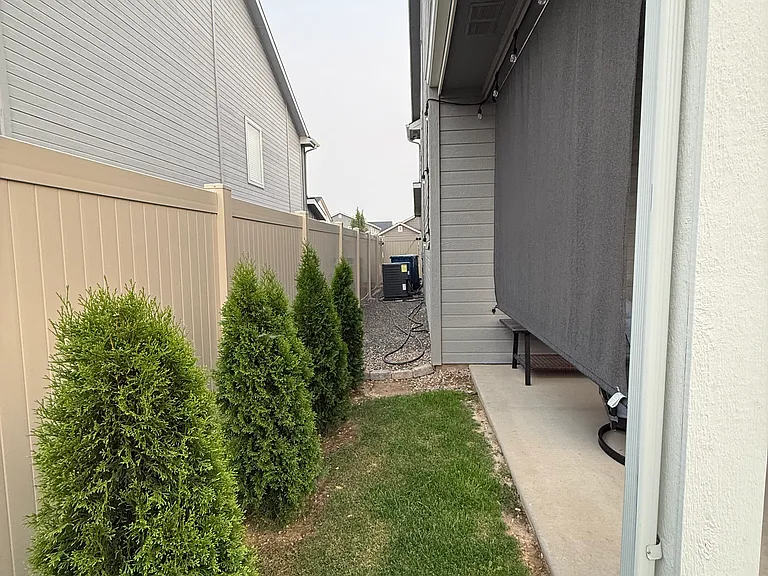 Side yard with privacy fencing and landscaping.