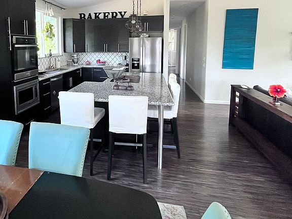Kitchen island seats 5-6 people comfortably. Open concept to large living room with split level A/C and bathed in natural light.