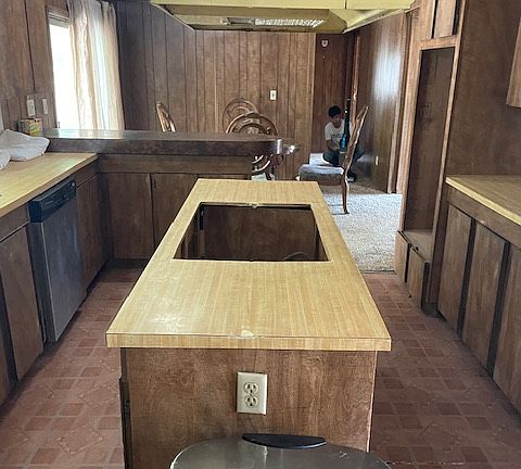 Full kitchen with the dining area just beyond. Sliding door on the left opens up to fenced in side yard where you can barbecue.