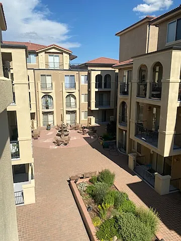 Courtyard view from the balcony (outside the living room and both bedrooms). This common area is shared by residents and includes outdoor grill and tables.