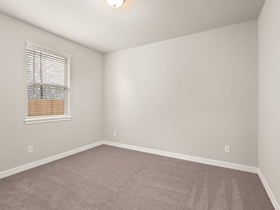 The second bedroom bedroom features plush carpet, fresh paint, closet, and a large window that lets