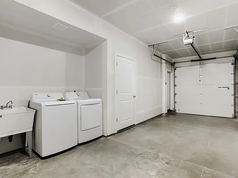 8 foot garage door with included washer and dryer. Laundry sink and door to yard.
