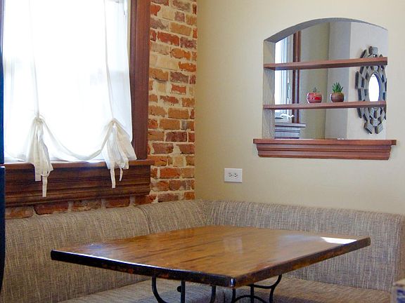 Charming dining nook with exposed brick wall.