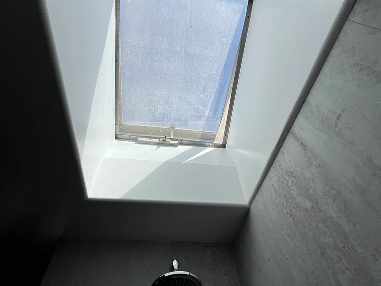 Pop-up skylight above shower