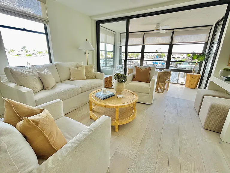 Comfortable slip covered sofa and swivel chairs with additional stools tucked under TV console allowing for ease of movie night and conversation