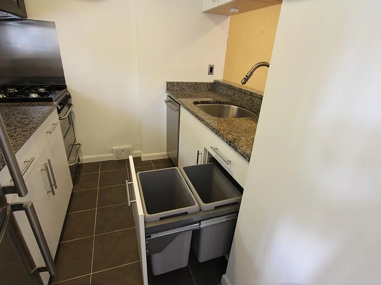 Kitchen with trash and recycle bins