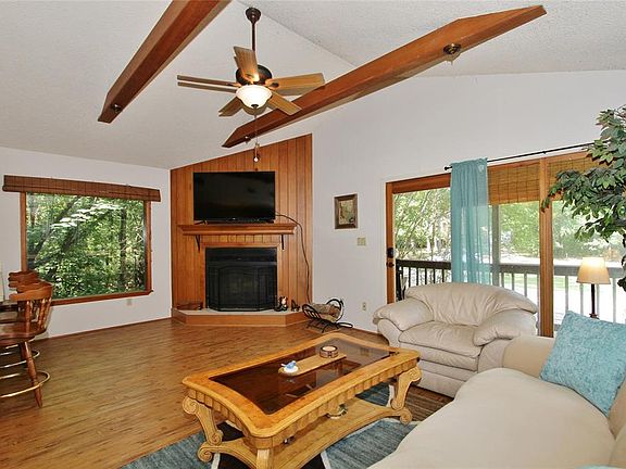 It also features a vaulted, wood-beamed ceiling and cozy fireplace and access to the covered deck.