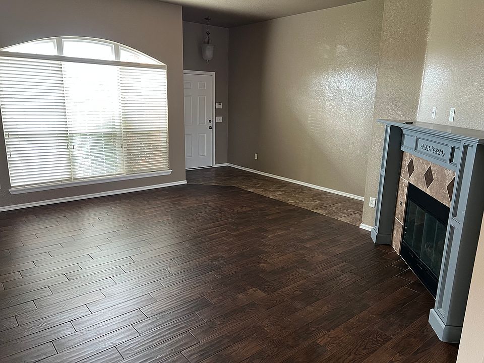 Living room has wood look tile, with Gas log fireplace
