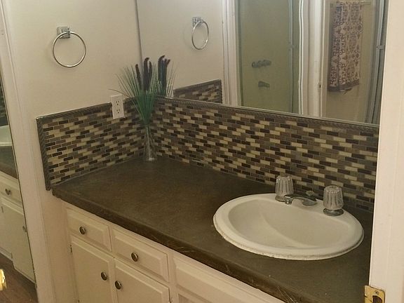 Bathroom sink , countertop, and cabinets. The window above t