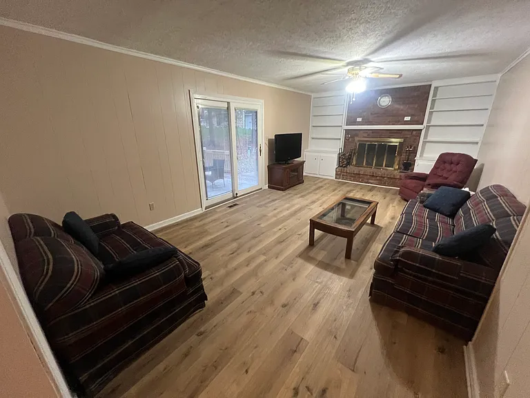 Huge master family room, fireplace, tools included, freshly painted new LVP flooring, furnished with couch and matching loveseat, matching La-Z-Boy, glass coffee table, TV and stand, glass end table
