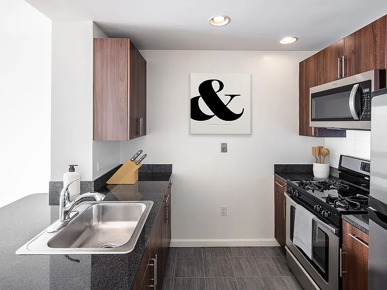 Classic Package I kitchen with gourmet kitchens including granite counter tops, stainless steel Whirlpool appliances, gas stovetop, and hard surface flooring