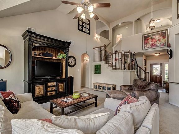 Vaulted ceiling and sweeping staircase creates architectural interest in the great room.